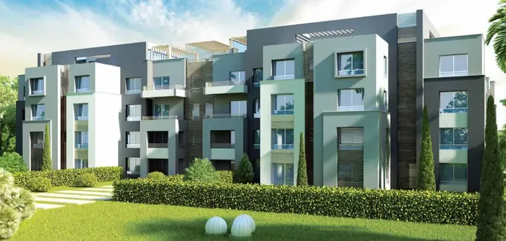عمارات سكنية بواجهات خضراء ورمادية وسط حديقة في كابيتال جاردنز