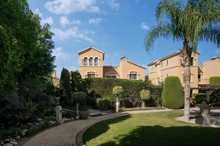 Mediterranean-style villa facades around an open lawn in Katameya Hills