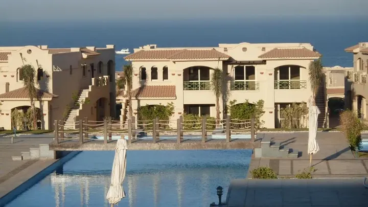Mediterranean-style chalets around a pool with a sea view