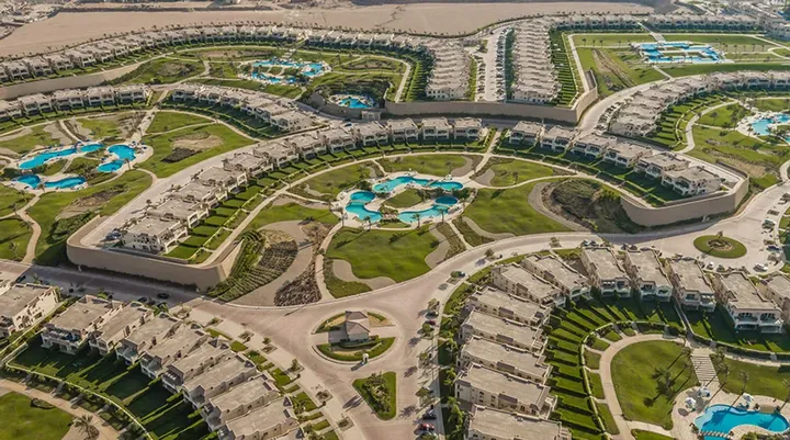 Aerial view of curved unit clusters, pools and gardens