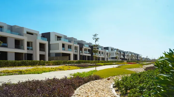 Row of modern townhouses facing a stone path and lawns