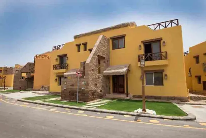 مبنى بواجهة صفراء وبرج حجري على أحد شوارع القرية