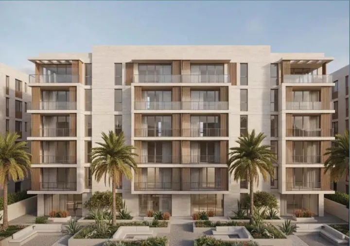 واجهة عمارة سكنية بشرفات متتابعة ونخيل في المدخل